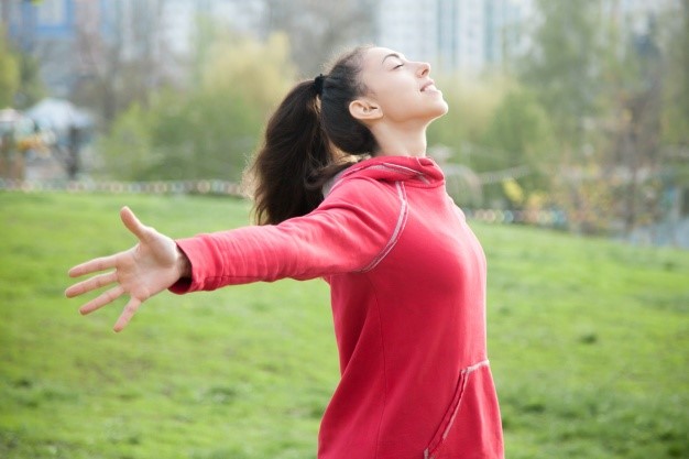 Femme respirant à bras ouverts